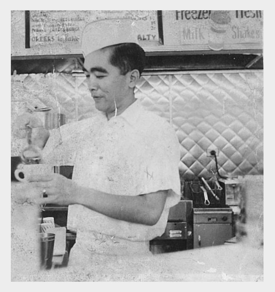 Paul Yamauchi's father, Tom, prepares a meal for patrons at Hamburger King restaurant. (Courtesy the Yamauchi family)
