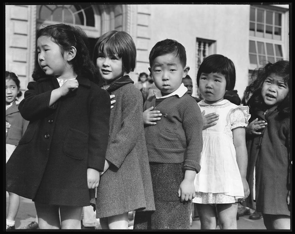 In April 1942 — days before they were forcefully relocated — Japanese-American students in San Francisco began their morning by reciting the Pledge of Allegiance. (Dorothea Lange, War Relocation Authority)