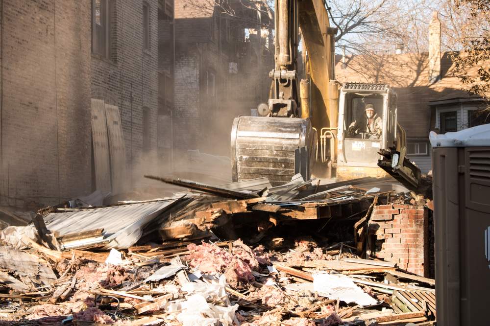 A worker plows through a plume of dust and debris on a demolition site in the Uptown neighborhood. (City Bureau/Manny Ramos)