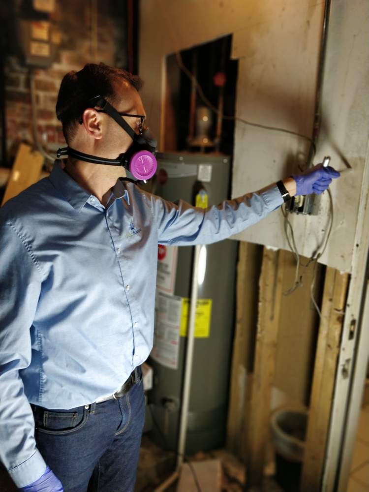 Environmental consultant Ian Cull inspects for asbestos at a client's home. (Courtesy Indoor Sciences, Inc.)