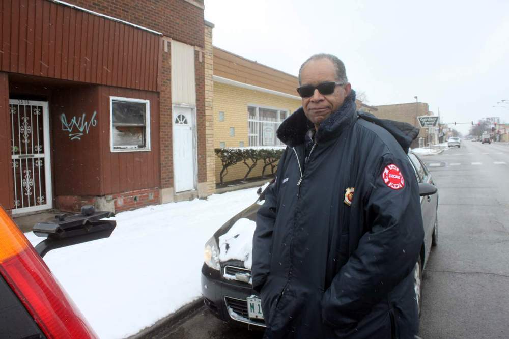 Larry Langford stands in front of the boarded up building where Rockwell Hall headquarters used to be located. (WBEZ/Jesse Dukes)