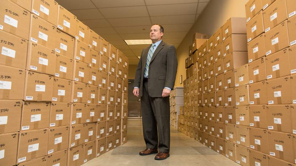 Neil Troppman, program manager for the ATF National Tracing Center, stands in front of boxes of gun reciepts.&amp;nbsp;(Raymond Thompson Jr. for WBEZ)