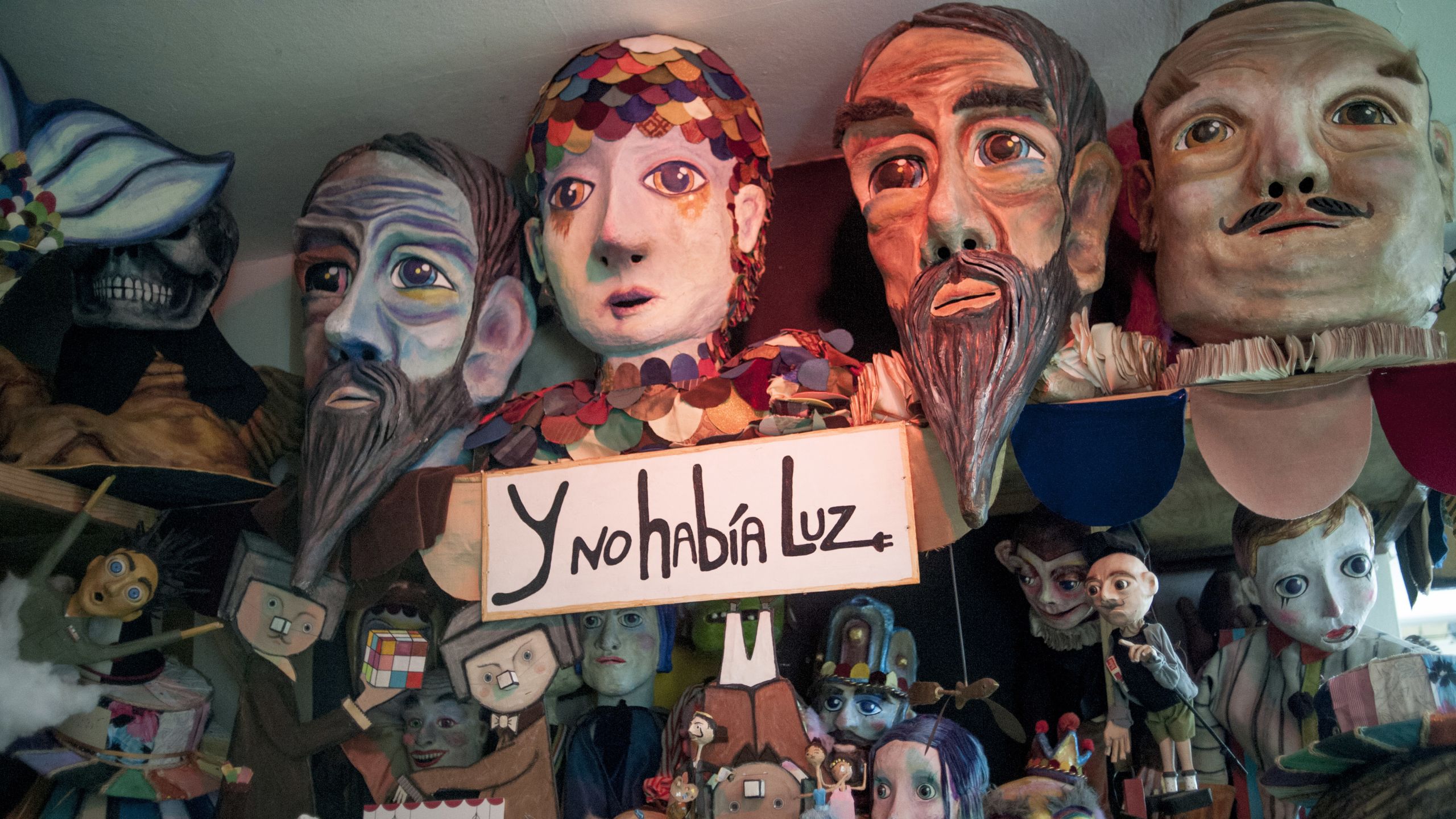 A collection of large puppet heads and smaller puppets.